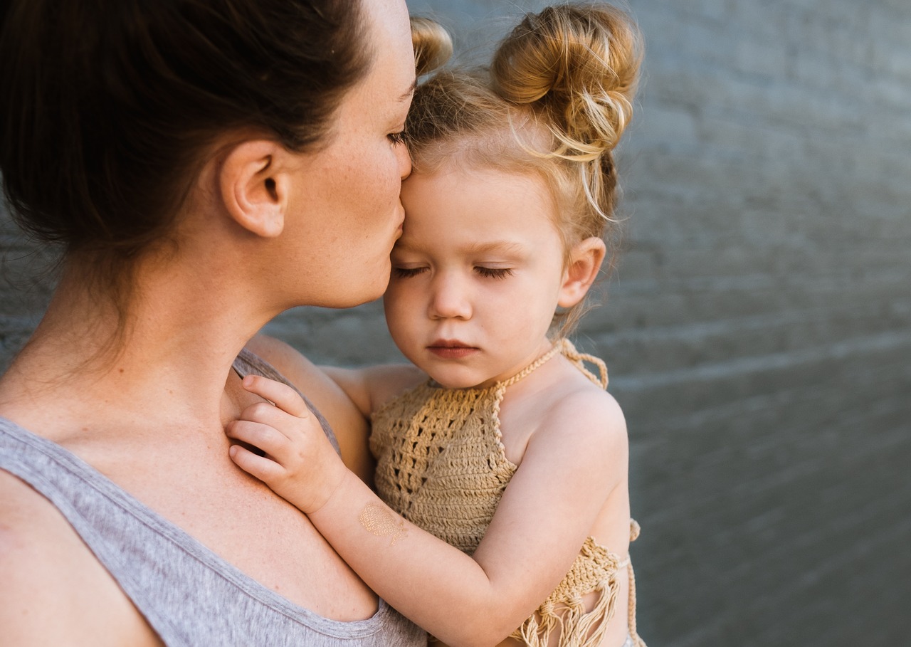 Mother kissing child's forehead