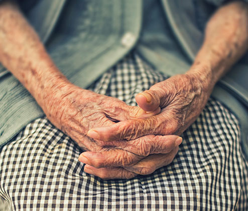 older person holding hands