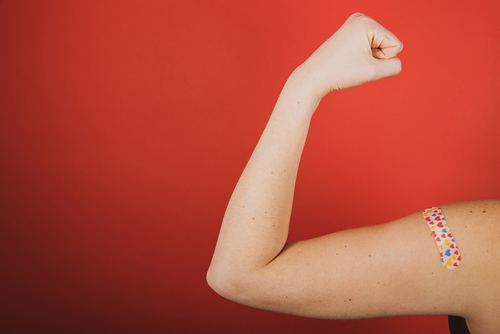 Person flexing arm after vaccination